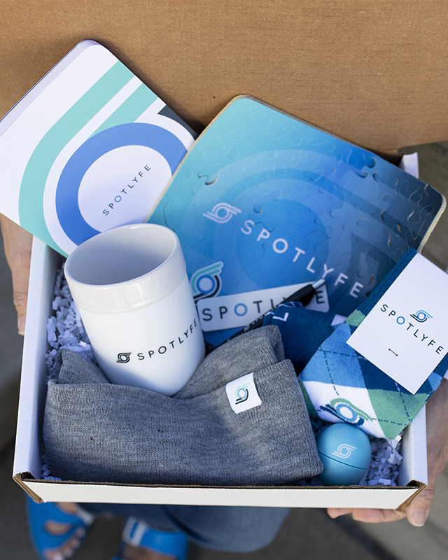 Swag box for new hires filled with custom branded mug, custom branded socks, and custom branded puzzle mousepad.